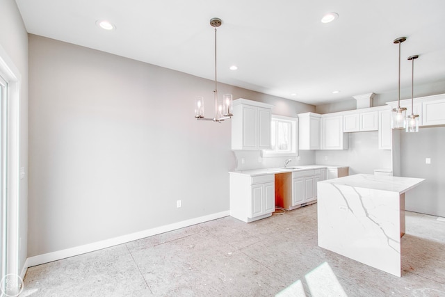 kitchen featuring white cabinetry, an inviting chandelier, light stone counters, and pendant lighting