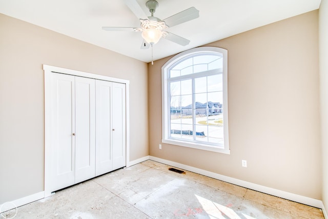 unfurnished bedroom with a closet, multiple windows, and ceiling fan