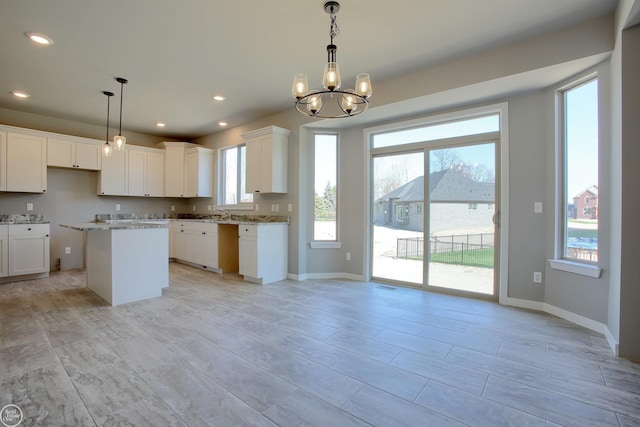 kitchen with pendant lighting, plenty of natural light, white cabinetry, and a center island