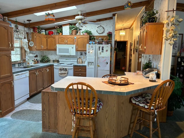 kitchen featuring sink, white appliances, a breakfast bar area, ceiling fan, and lofted ceiling with beams