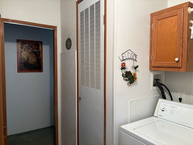 clothes washing area featuring cabinets and washer / clothes dryer