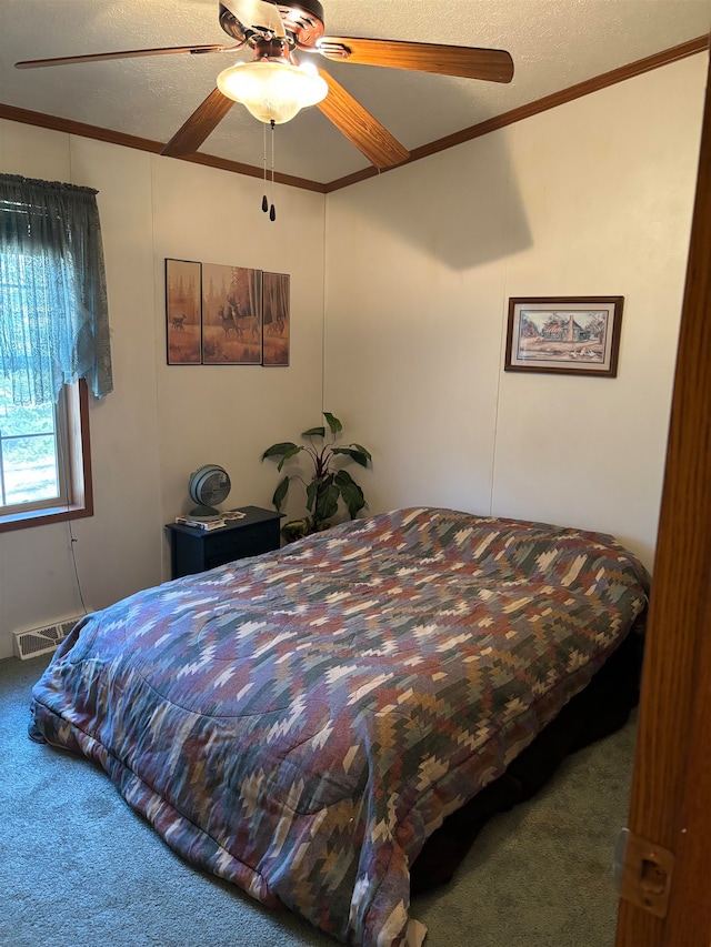 carpeted bedroom featuring ornamental molding, a textured ceiling, and ceiling fan