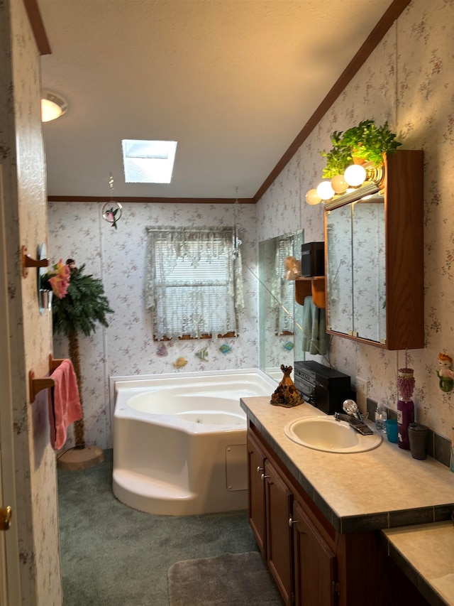 bathroom with vanity, crown molding, lofted ceiling with skylight, and a tub