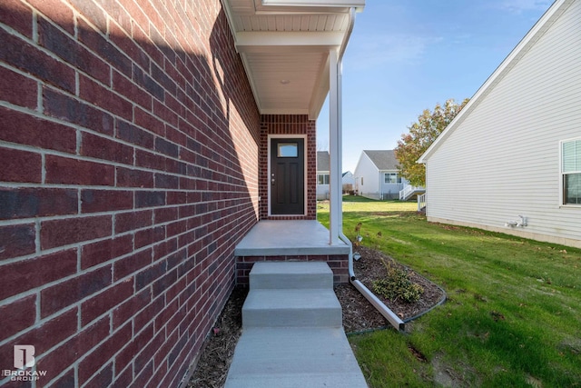 entrance to property featuring a lawn