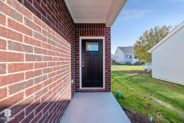 doorway to property featuring a lawn