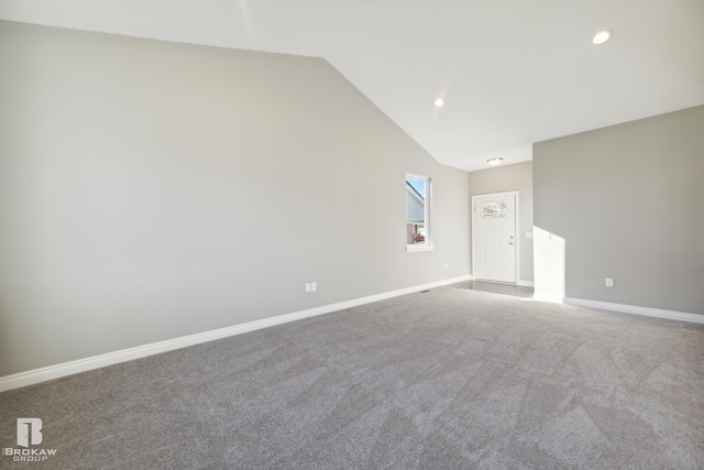 unfurnished room with carpet floors and lofted ceiling