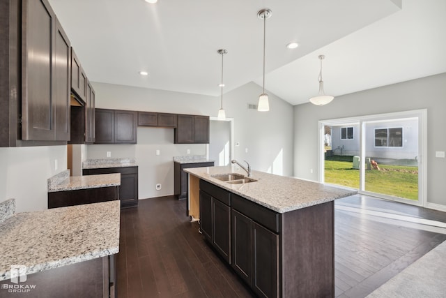 kitchen featuring dark hardwood / wood-style flooring, a kitchen island with sink, pendant lighting, sink, and vaulted ceiling