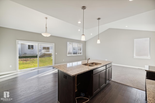 kitchen featuring sink, light stone counters, dark hardwood / wood-style flooring, vaulted ceiling, and decorative light fixtures