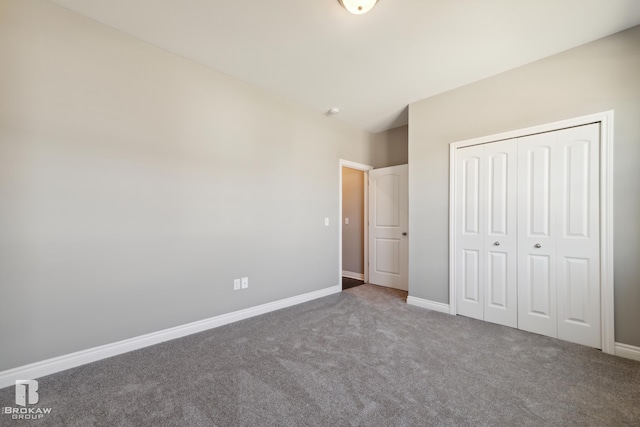 unfurnished bedroom featuring a closet and dark carpet