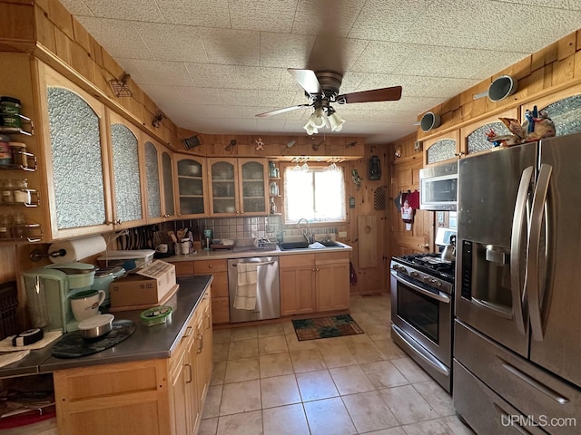 kitchen featuring ceiling fan, appliances with stainless steel finishes, light tile floors, and sink