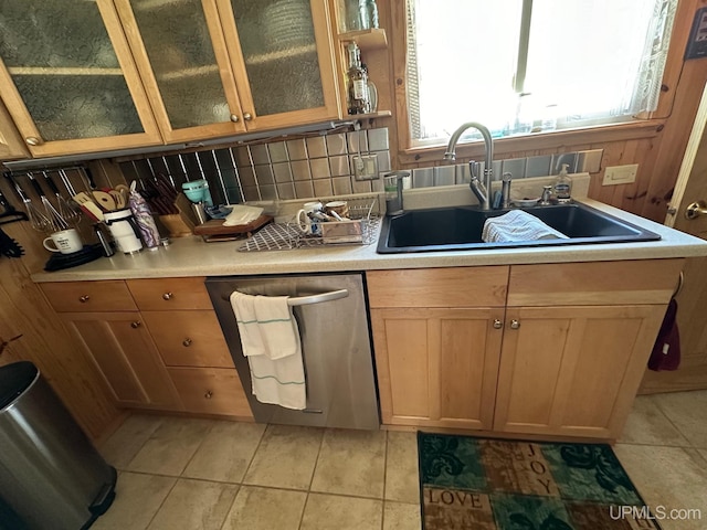 kitchen with light tile floors, backsplash, dishwasher, and sink