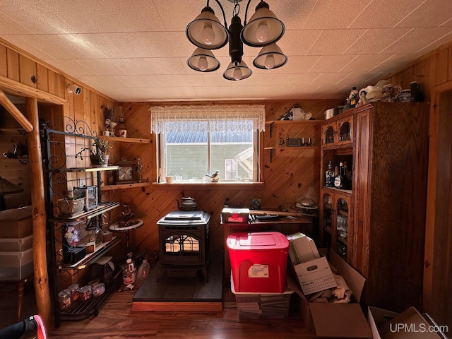 office with wooden walls, a wood stove, and dark hardwood / wood-style flooring