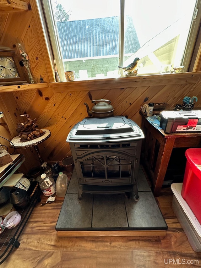 interior space featuring wood walls, dark hardwood / wood-style floors, and a wood stove