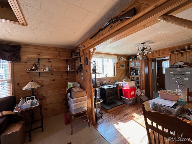 misc room featuring dark hardwood / wood-style flooring, wood walls, and a wood stove