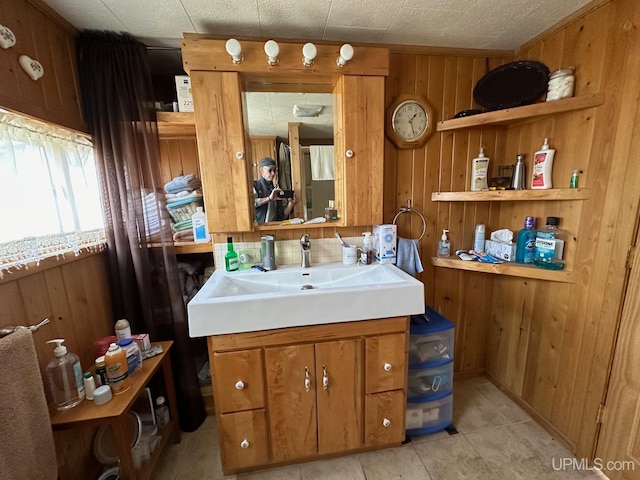 bathroom with vanity, wood walls, and tile flooring