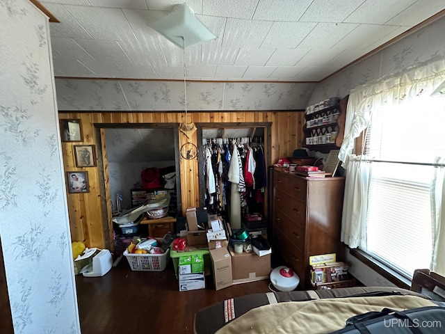 bedroom featuring a closet and wooden walls