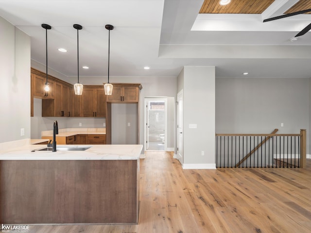 kitchen featuring hardwood / wood-style floors, plenty of natural light, pendant lighting, and sink