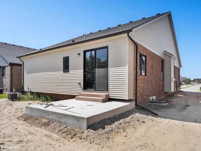 rear view of house with central AC and a patio area