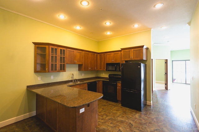 kitchen featuring dark tile flooring, dark stone counters, sink, and black appliances