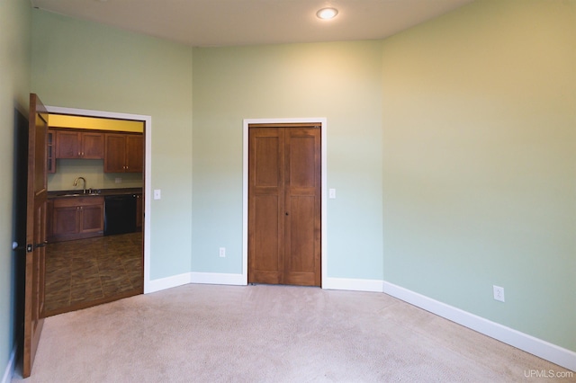 unfurnished bedroom featuring light carpet and sink