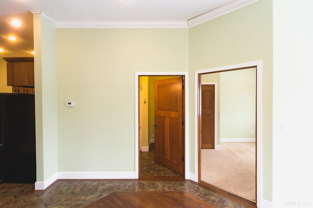 empty room with ornamental molding and dark carpet