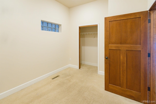 unfurnished bedroom featuring a closet and light carpet