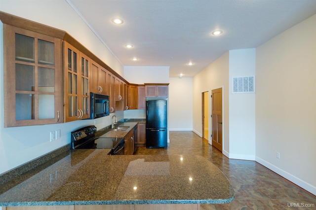 kitchen with dark stone counters, ornamental molding, black appliances, and sink