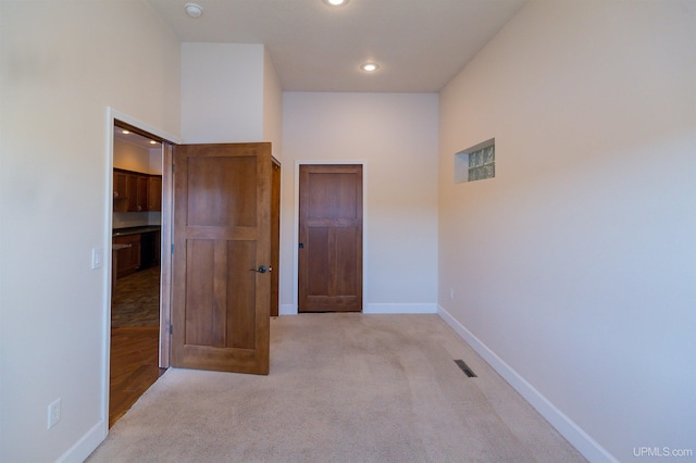 unfurnished room with light colored carpet