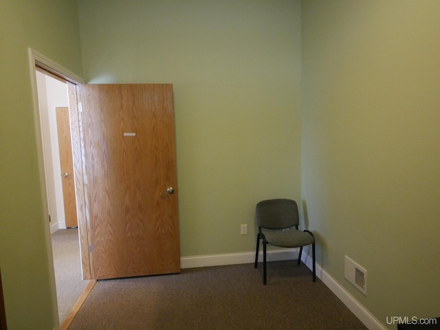 unfurnished room featuring dark colored carpet