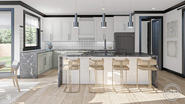 kitchen featuring high end refrigerator, hanging light fixtures, a breakfast bar area, and a kitchen island