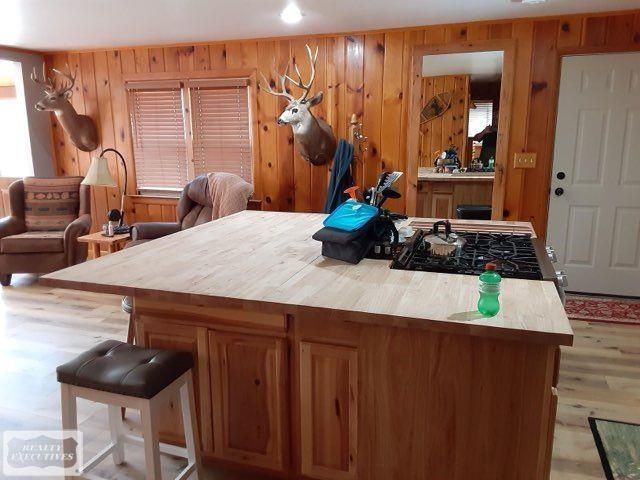 kitchen with hardwood / wood-style floors, wooden walls, and range