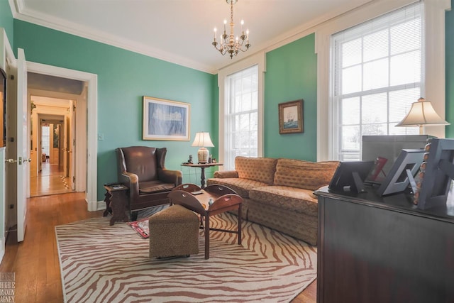 living room with a chandelier, light hardwood / wood-style flooring, and crown molding