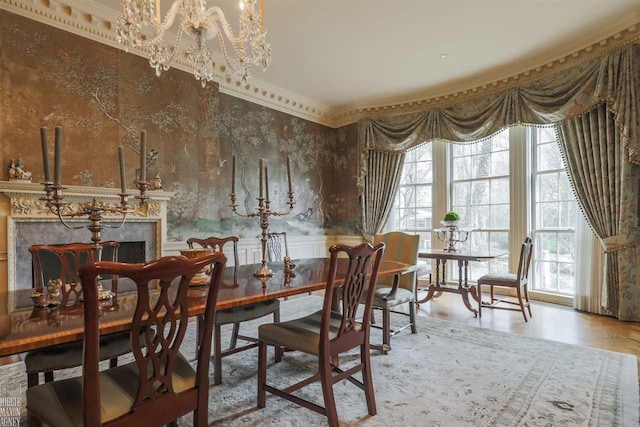 dining area featuring crown molding, light wood-type flooring, and an inviting chandelier