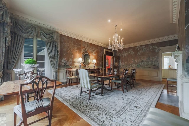 dining area with light parquet floors, an inviting chandelier, and ornamental molding