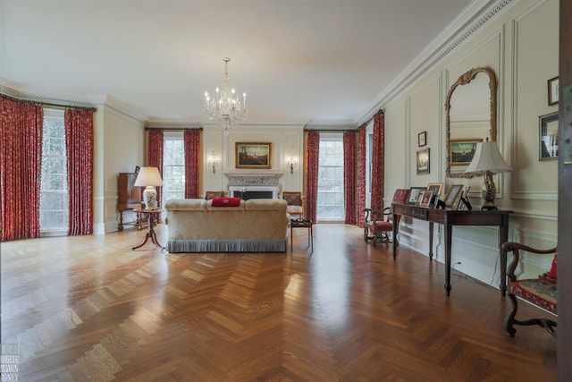 living room featuring ornamental molding, a chandelier, and light parquet flooring