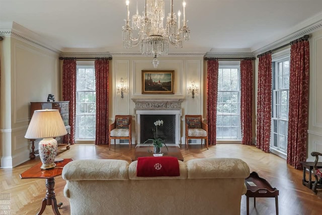 living room with a chandelier, light parquet floors, ornamental molding, and plenty of natural light