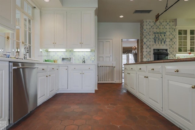 kitchen with black oven, dark tile flooring, dishwasher, sink, and white cabinetry