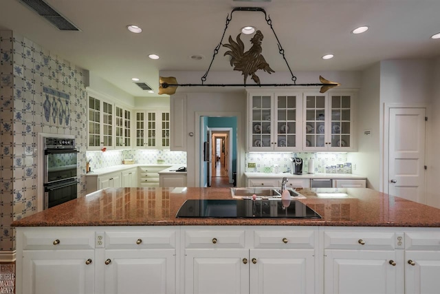 kitchen with white cabinetry, black appliances, and a center island