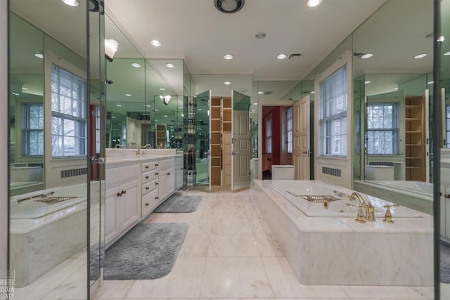 bathroom featuring tile flooring, large vanity, and tiled tub