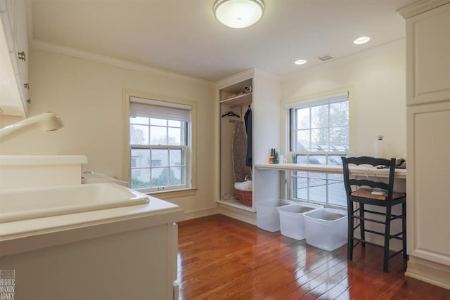 bathroom with a healthy amount of sunlight, hardwood / wood-style flooring, and ornamental molding