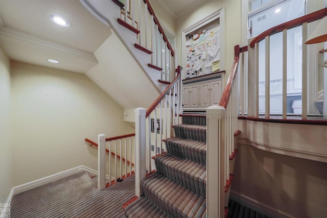 stairs featuring dark colored carpet and crown molding