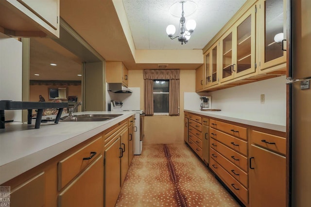 kitchen featuring stainless steel fridge, a notable chandelier, sink, stove, and pendant lighting