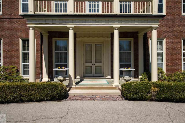 doorway to property with a balcony and covered porch