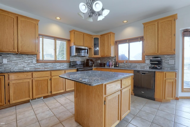 kitchen with black appliances, an inviting chandelier, backsplash, dark stone counters, and a kitchen island