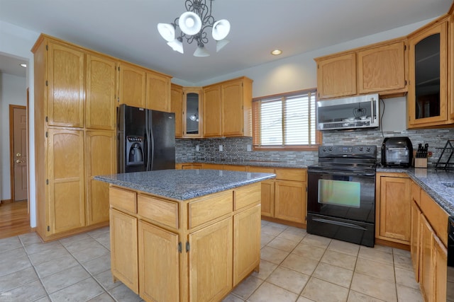 kitchen with a chandelier, tasteful backsplash, light tile floors, a center island, and black appliances