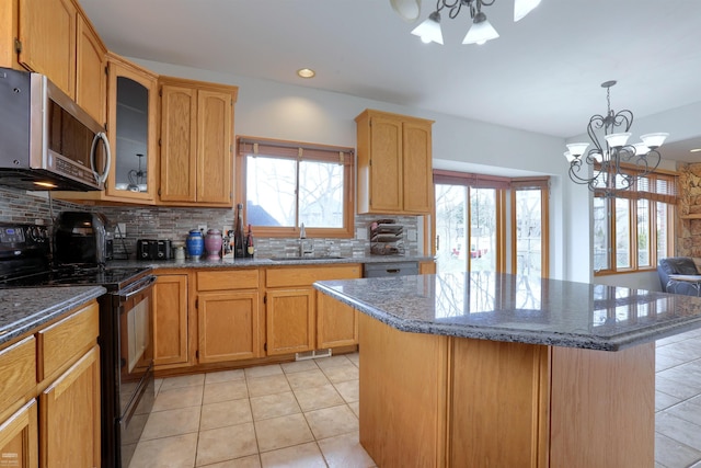 kitchen with a notable chandelier, backsplash, black appliances, and light tile floors