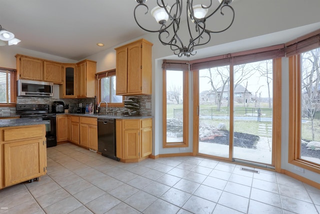 kitchen featuring an inviting chandelier, pendant lighting, light tile flooring, backsplash, and black appliances