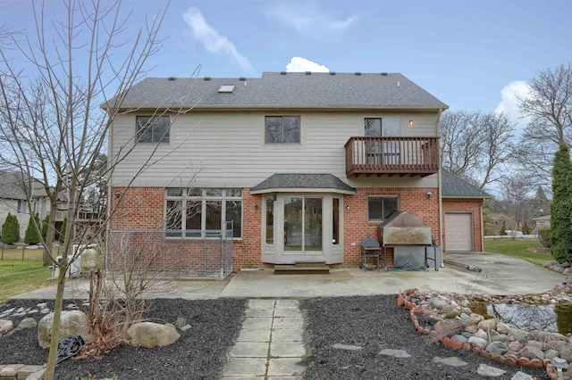 back of house featuring a balcony and a garage