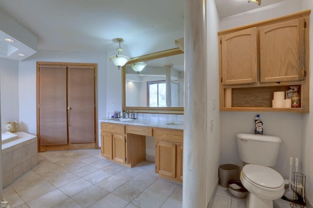 bathroom featuring tile flooring, ceiling fan, toilet, vanity, and a bathtub