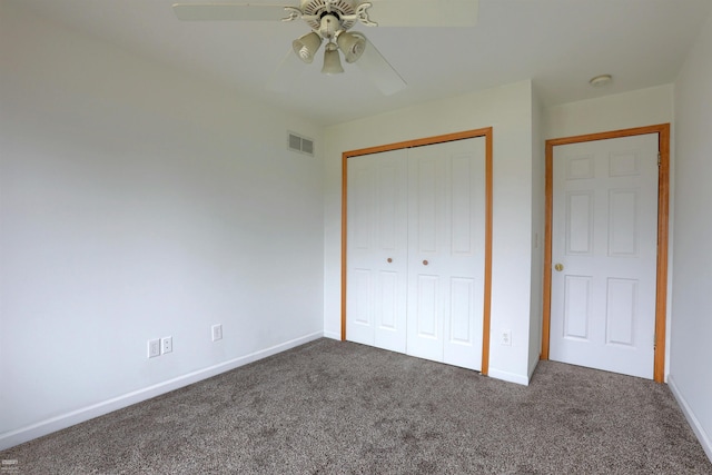 unfurnished bedroom with ceiling fan, a closet, and dark colored carpet